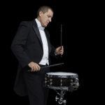 James Babor playing snare in tuxedo