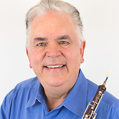 Image of man holding a woodwind instrument.