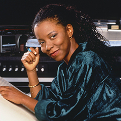 Image of a woman near a keyboard and music paper.