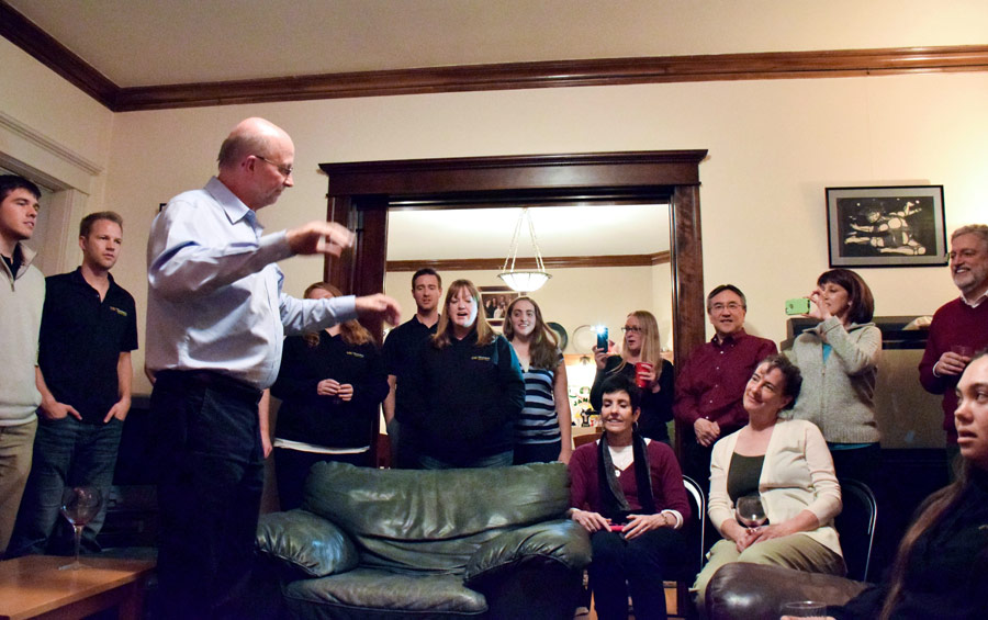 Jo-Michael Scheibe leads the Chamber Singers in an impromptu performance during a party hosted by the parents of student Antona Yost, a native of Salt Lake City.