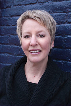 Lynn Helding pictured on blue brick background