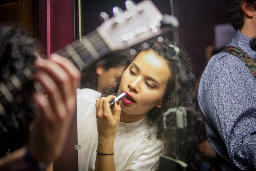 Camila Mora, a junior vocalist, applies lipstick in the Troubadour “green room” (its walls are actually purple). (USC Photo/David Sprague)