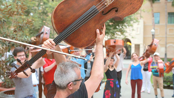 Photo of group of cellists with their instruments outdoors 