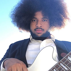 Portrait of Brian Robert Jones playing bass in a suit