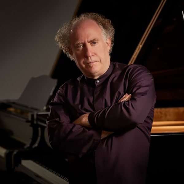 Jeffrey Kahane standing against piano.