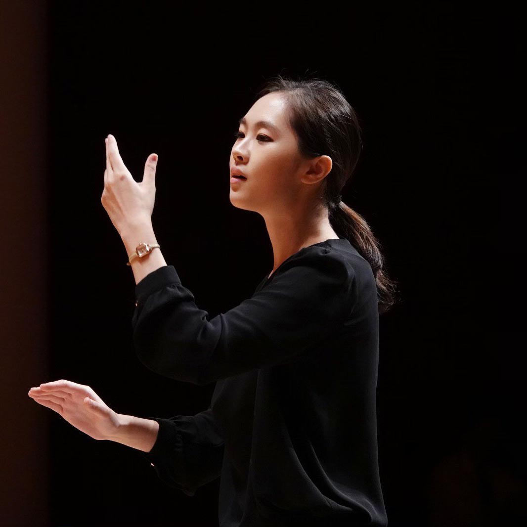 Photo of Heesong Lee in concert attire conducting a choir.
