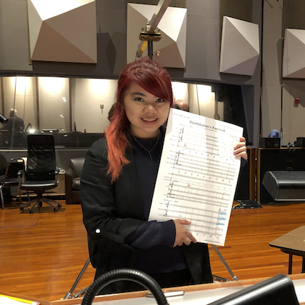 Photo of Jaimie Pangan in studio, holding up score