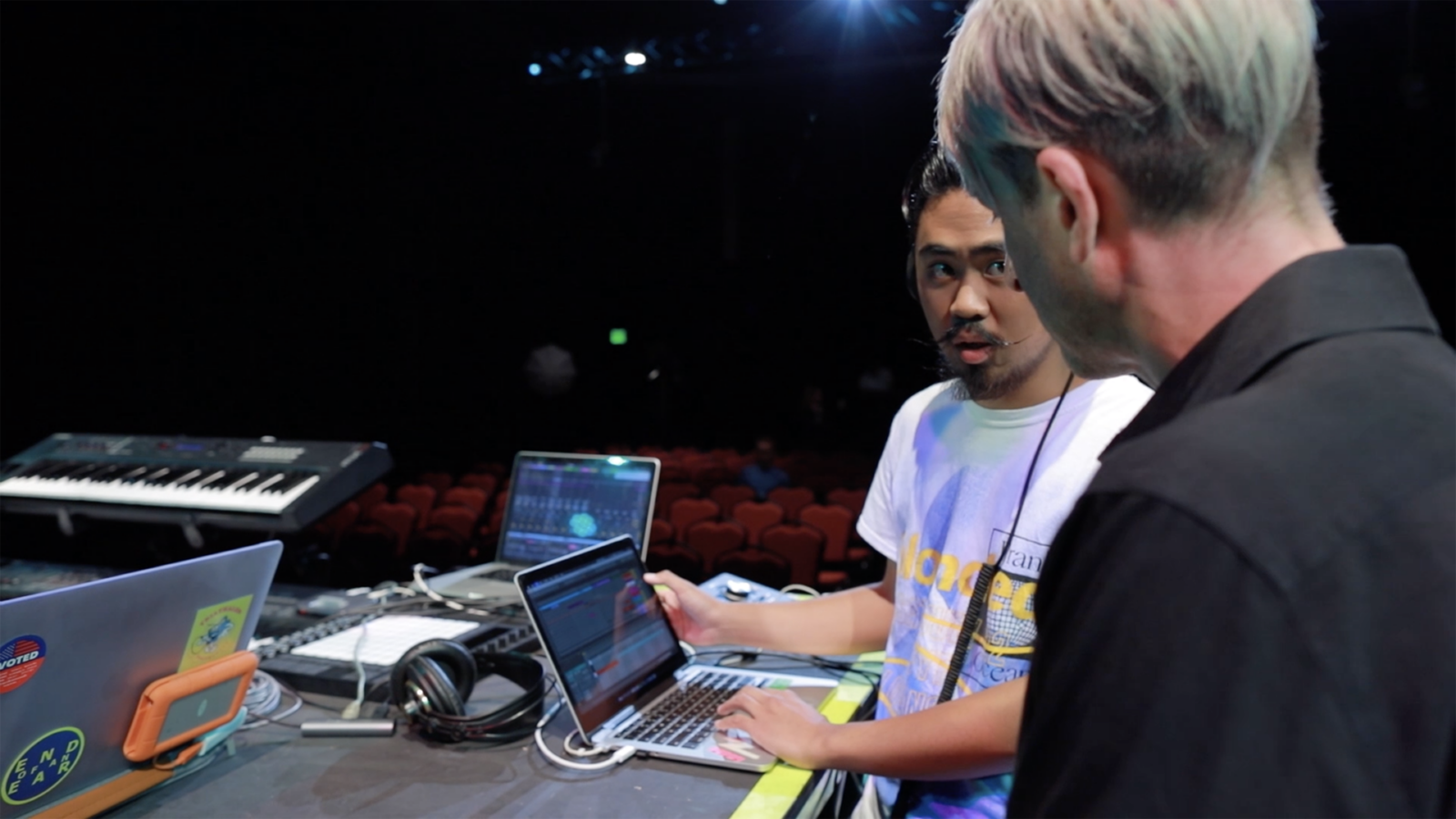 photo of student speaking to professor on stage 