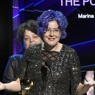 Nadia Schpachenko in black dress at microphone accepting award