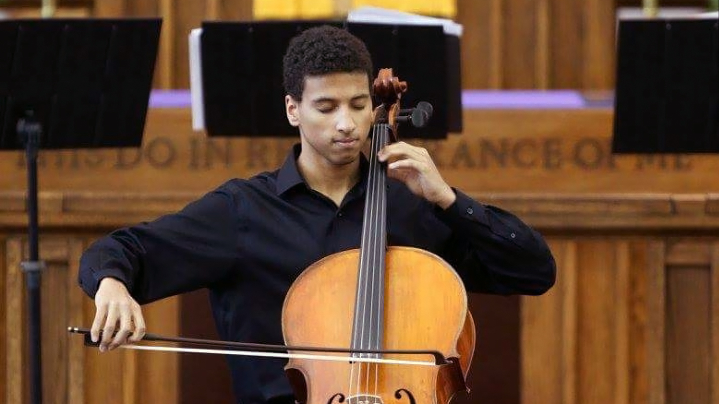 Myles Yeazell dressed in concert black playing the cello