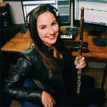 Gina Luciani holding flute with headphones on
