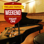 Picture of a piano in Schoenfeld Hall with a logo reading "Trojan Family Weekend - Fight on!"