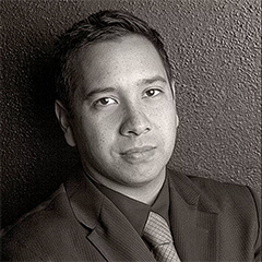 Black and white portrait of Angel Velez in suit and tie
