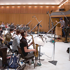 Musicians in a recording studio following a conductor