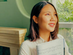 Smiling student holding sheet music