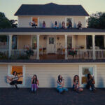 Musicians perform on a rooftop at sunset