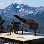 Hunter Noack performs outdoors on a Steinway grand piano in front of a mountain