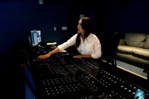 Photo of Danielle Dupre in front of a mixing board at Skywalker Sound.