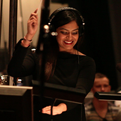 Photo of Raashi Kulkarni conducting in a screen scoring session at a recording studio
