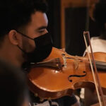 A strings student performs with the orchestra at Capitol Studios.
