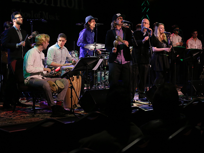 Jazz student ensemble performs on stage with percussion instruments.
