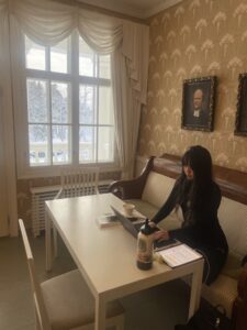 Student works on a laptop indoors between rehearsals. 