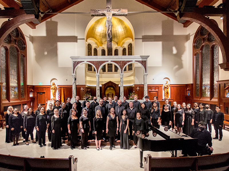 The University Chorus poses for a picture inside a church. 