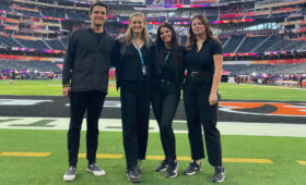 Music students and USC Thornton faculty member Sophie Reeves stand on a football field.