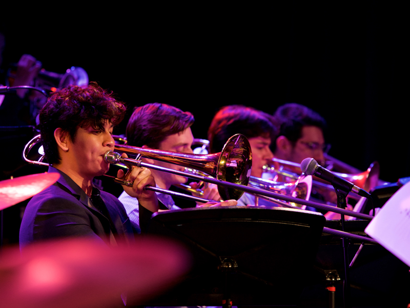 USC Thornton students in various attire perform the brass onstage. 