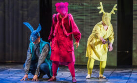 Opera singers in animal costumes perform on stage.