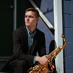 Photo of Branden Brown holding a saxophone.