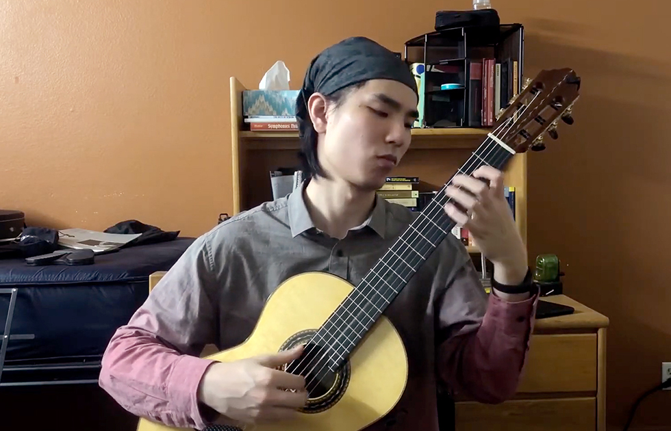 Photo of student lutenist playing in their dorm room.
