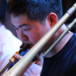 Photo of Jon Hatamiya playing a trombone
