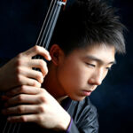 Photo of cellist Taeguk Mun holding his cello instrument.