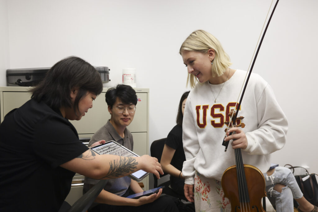 Photo of Yura Lee teaching a group of violin students
