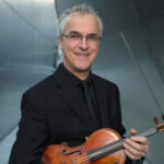 Photo of Martin Chalifour with his violin standing outside.
