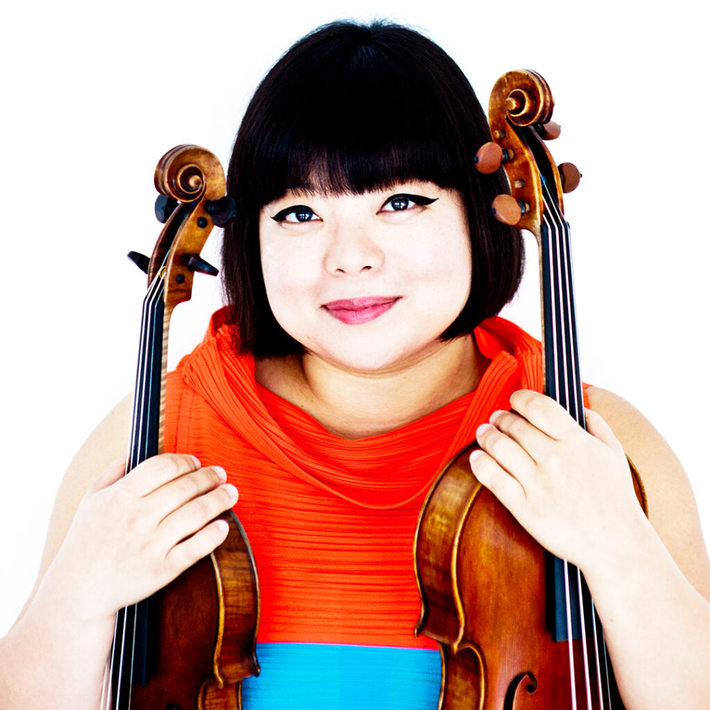 Photo of Yura Lee holding a violin and viola.