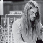 Black and white image of a German musician with long hair playing a keyboard from the 1970s.