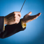 Photo of hands conducting with a baton.