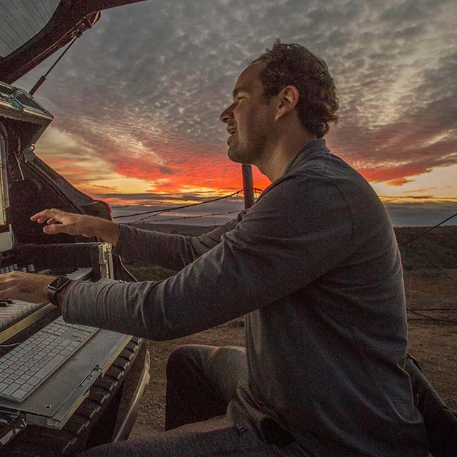 Photo of Cody Westheimer playing a keyboard outside.