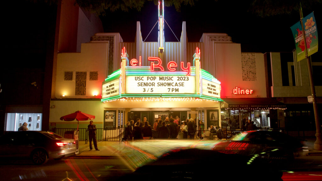 The exterior of a theatre marquee lit up at night.