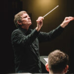 Photo of Frank Ticheli conducting a symphony orchestra