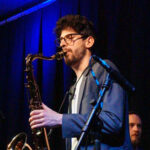 Photo of a saxophonist performing on stage.