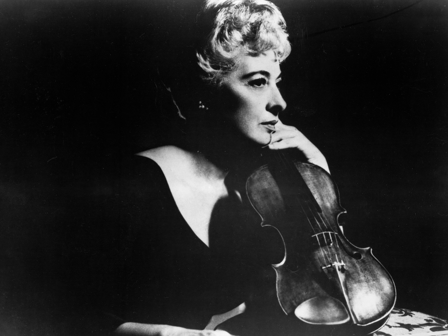 Black and white photo of Eudice Shapiro holding a violin. 