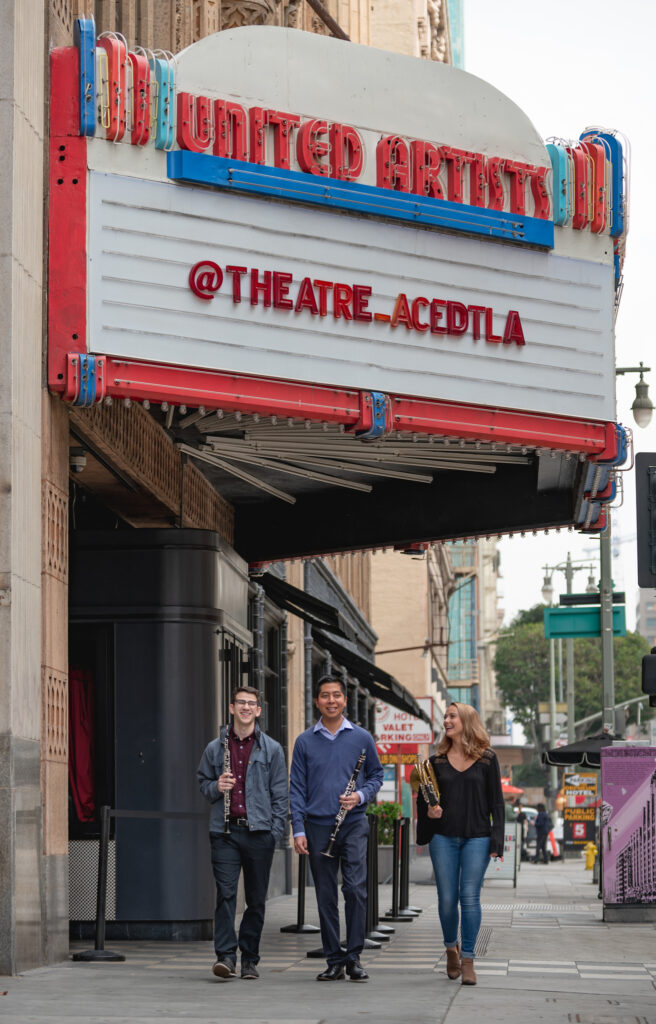 Photo of classical wind instrument student musicians walking down a city street for the USC Thornton Young Artist Project.