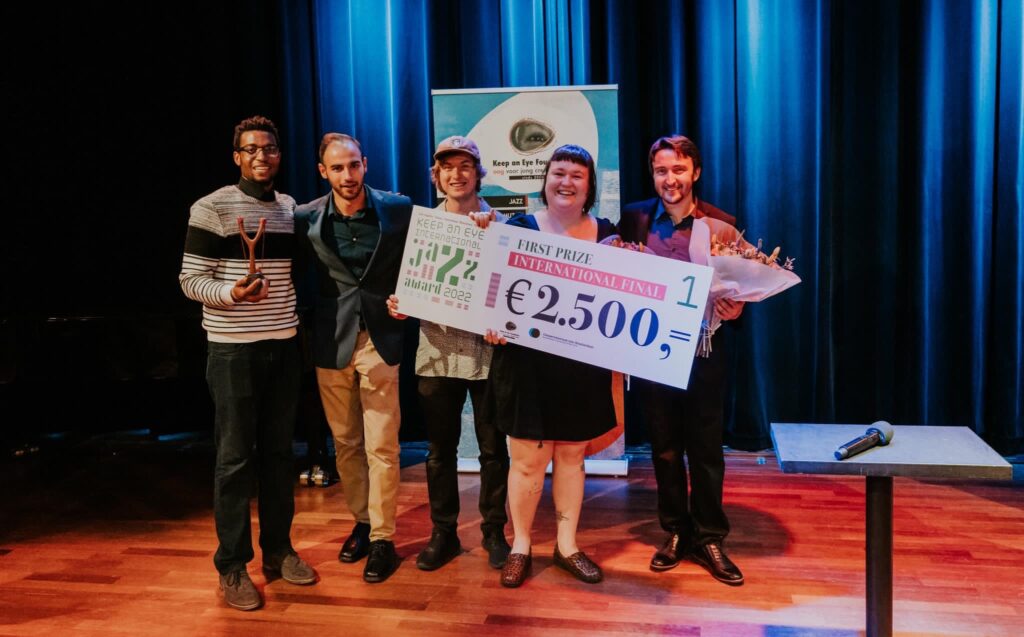 Photo of a quintet of jazz performance students accepting an award on stage with Nicole McCabe.