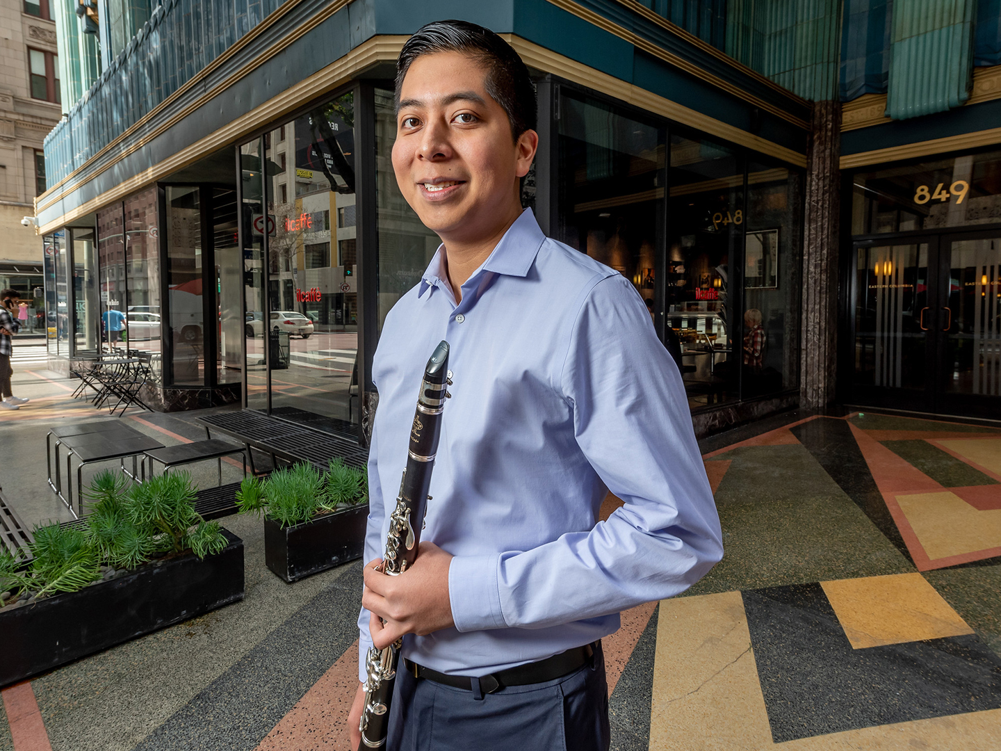 clarinetist holding his instrument outside in downtown Los Angeles. 