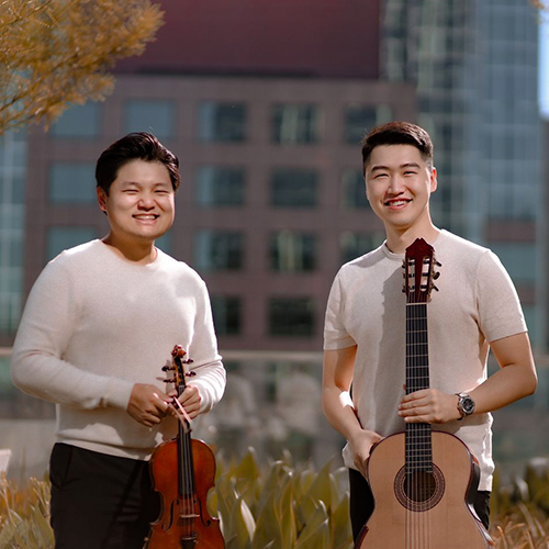 Two musicians holding a violin and a classical guitar.