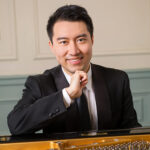 Photograph of Rixiang Huang with piano