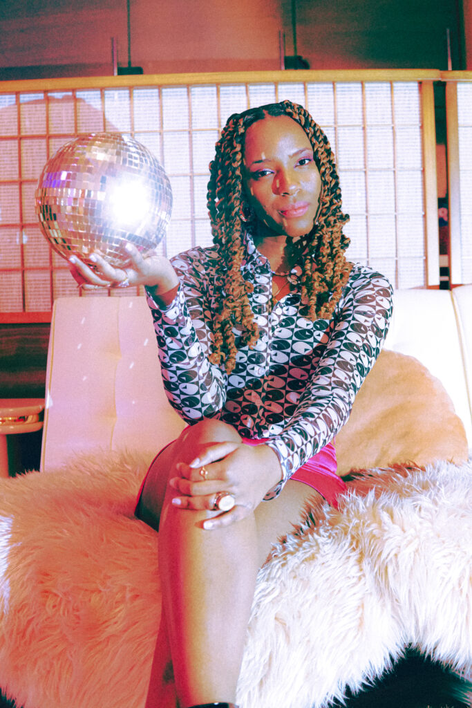A pop singer holding a miniature disco ball.